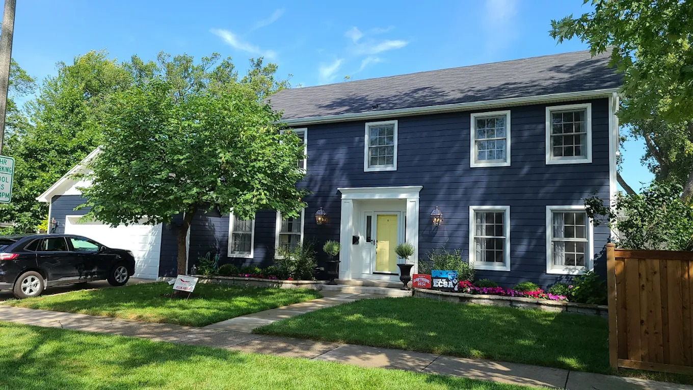 Dark colonial home in Elmhurst, Illinois with updated siding and exterior trim by Durabuilt Home Improvements