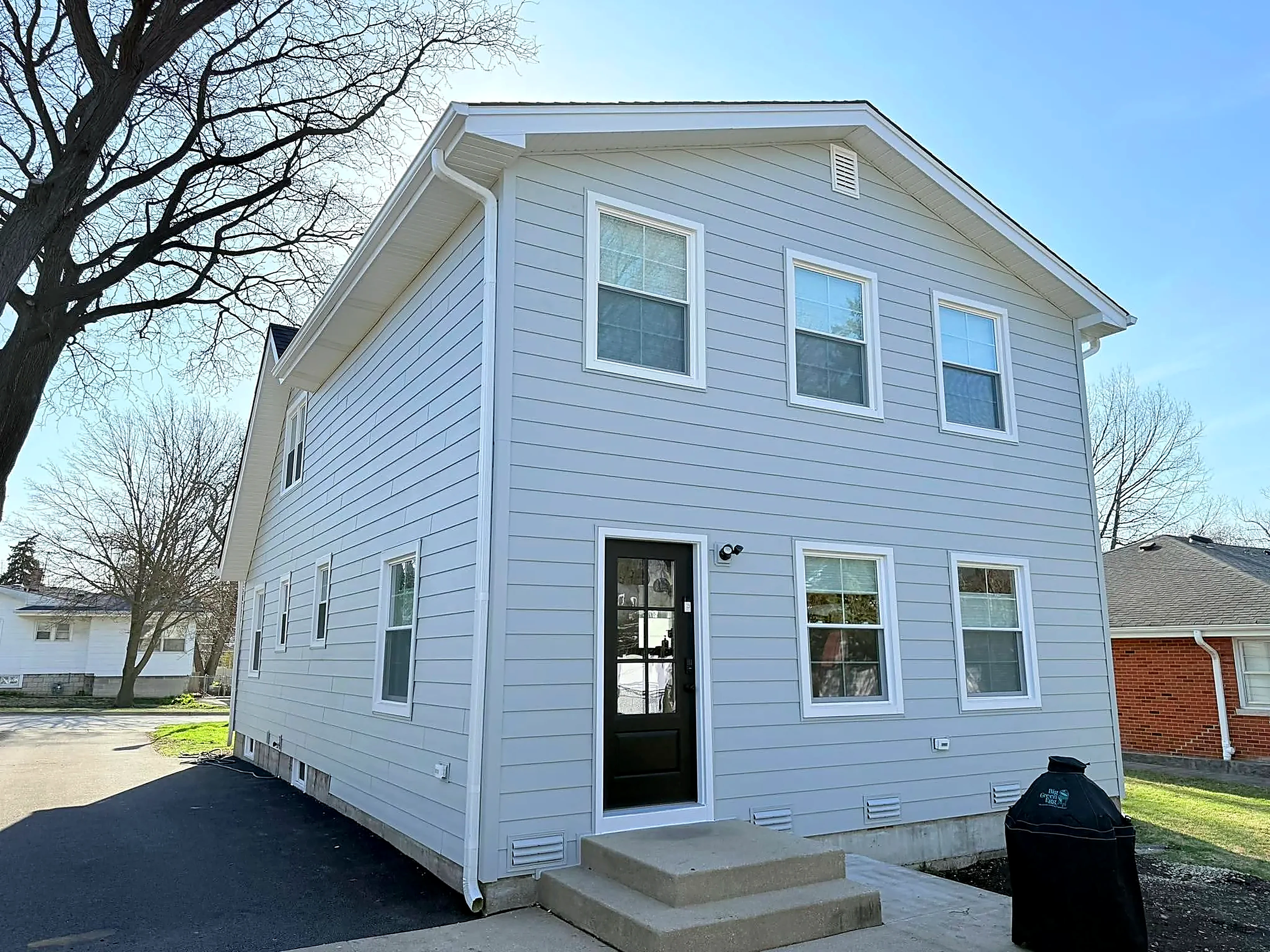 Completed exterior siding, window and trim replacement on a wraparound-porch home by Durabuilt Home Improvements in Elmhurst, Illinois